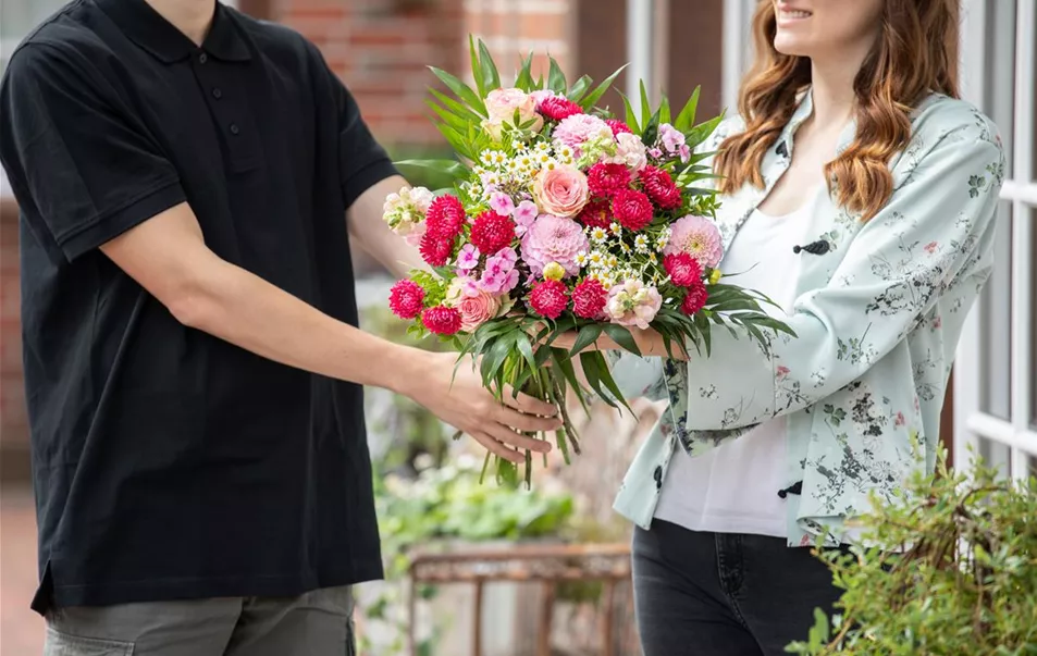 Lieferservice - Lieferant übergibt Blumenstrauß Lieferservice - Lieferant übergibt Blumenstrauß